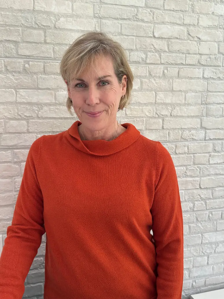 JJ orange jumper white brick wall